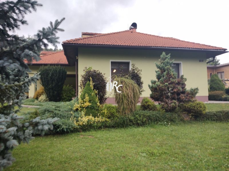 A family house in Trebostovo, with a landscaped garden featuring plants and trees in the front.