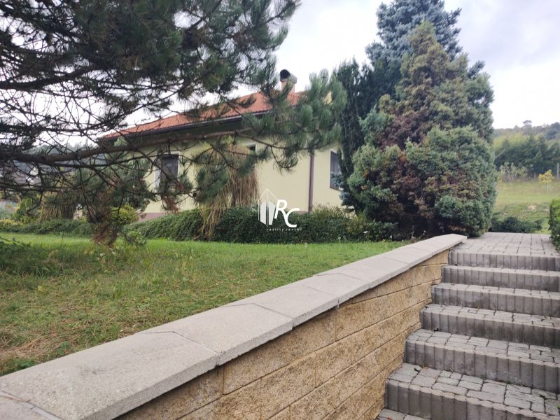 A family house in Trebostovo with greenery and a staircase made of concrete blocks.