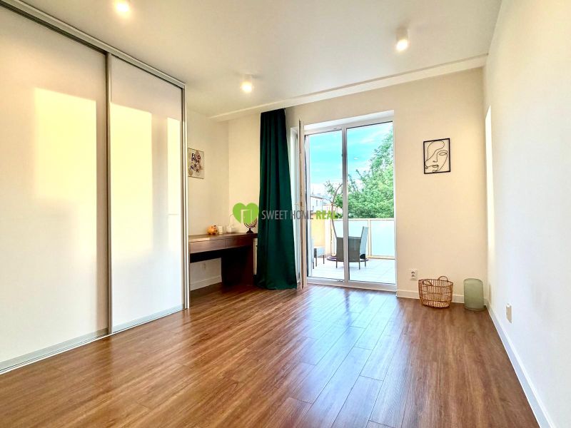 Interior of a 3-room apartment with a wooden decor floor and a spacious terrace.