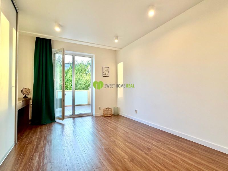 A bright room with access to a balcony, wooden decor flooring in a 3-room apartment.