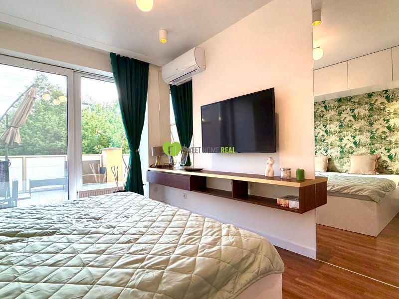 Bedroom in a 3-room apartment with large windows, green curtains, and a wooden decor floor.