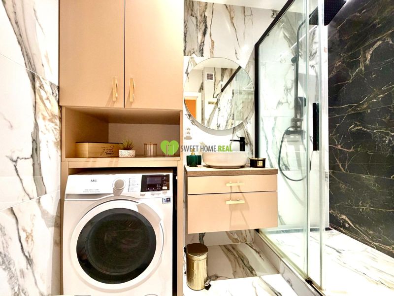 Bathroom in a 3-room apartment with a shower, sink, and washing machine.