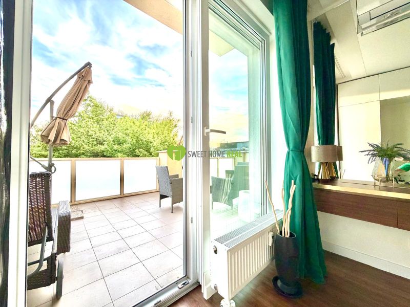 Interior of a 3-room apartment with a terrace, wooden decor flooring, green curtains.