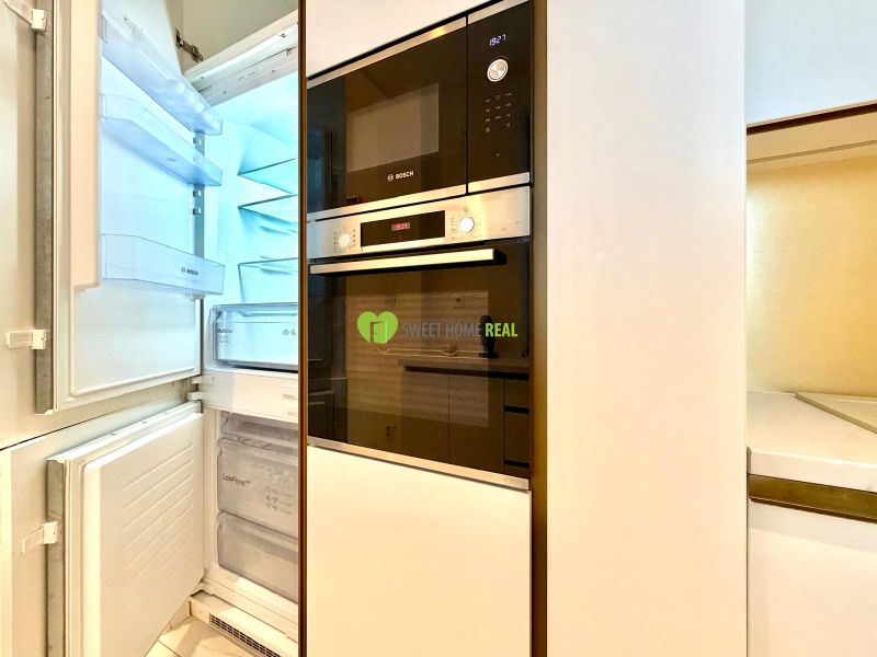 A kitchen unit with a refrigerator and built-in appliances in a 3-room apartment.