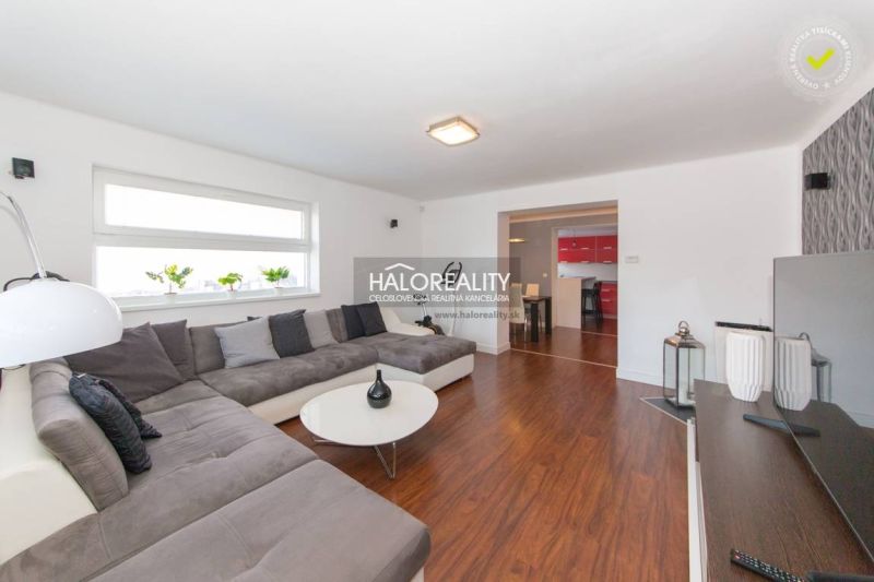 Interior of a family house with a wooden decor floor, large sofa, and modern seating.