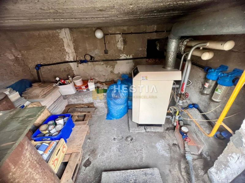 Boiler room in a family house with a boiler and piping, storage space for materials.