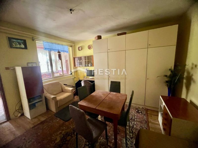 Living room in a family house with a wardrobe and a sofa, floor with wooden decor.