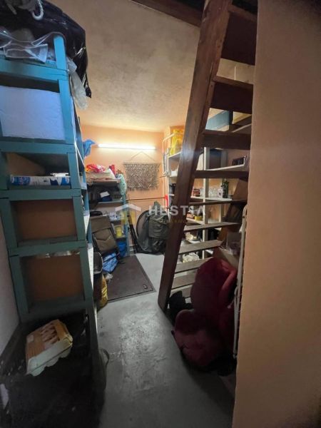 Storage space with shelves and staircase in a family house.