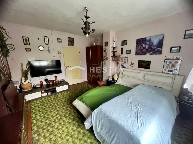 A bedroom in a family house with a carpet and decorations on the wall.