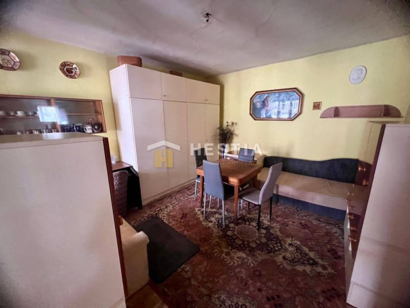 Living room with carpets, wooden decor, and simple furniture in a family house.