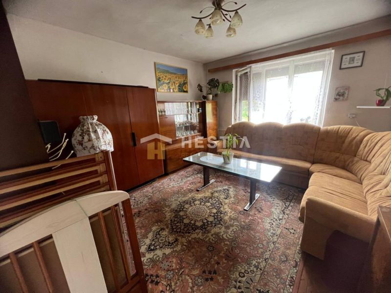 Living room in a family house with a carpet and a glass cabinet.