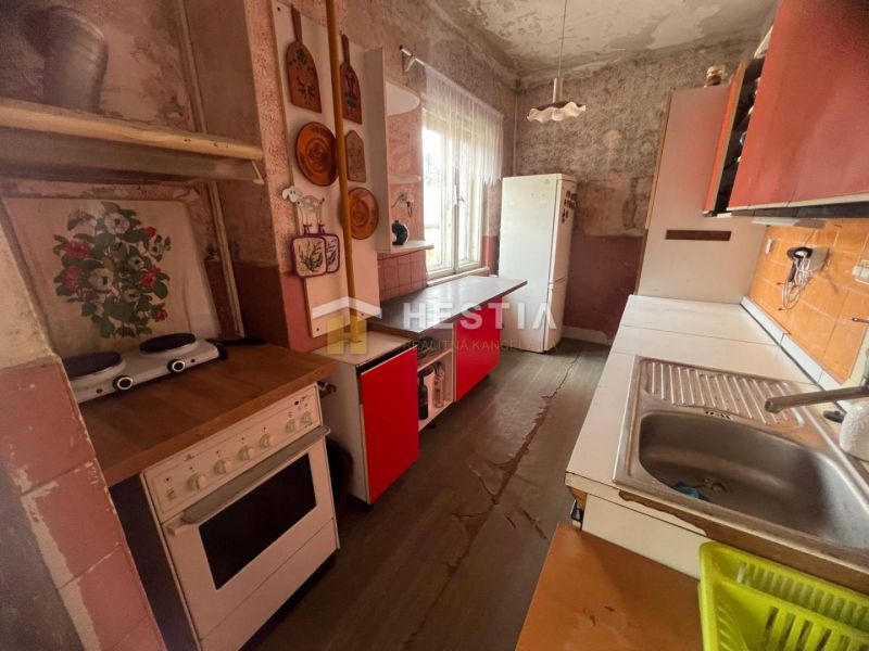 A kitchen in a family house with a wooden decor floor and retro furniture.