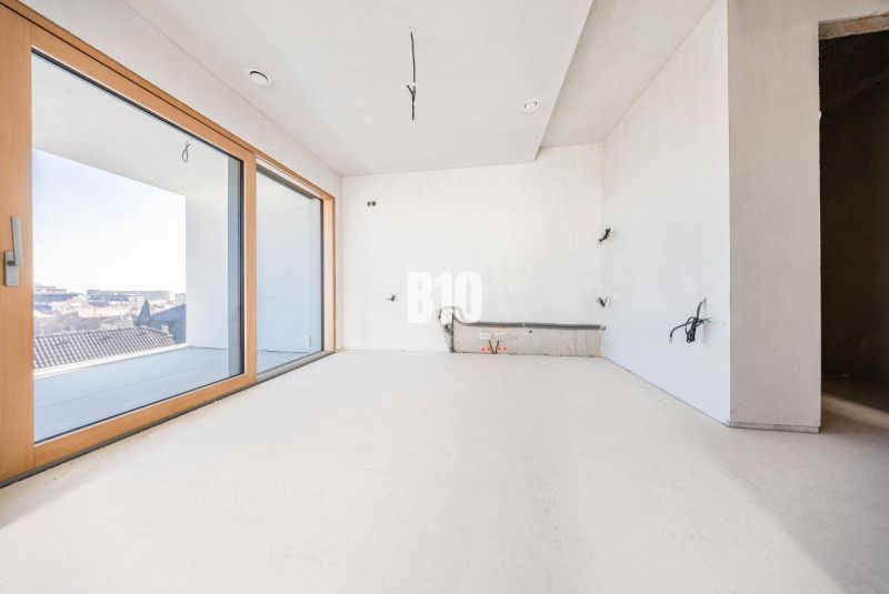 A room with large windows and a wooden decor floor in a 3-room apartment.