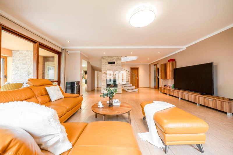Living room with wood-patterned flooring, orange sofa, and fireplace in a family house.