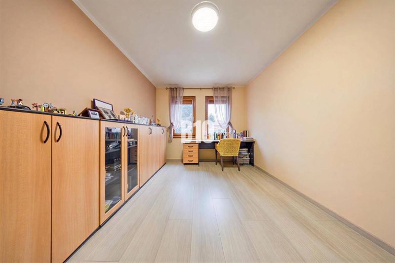 A study in a family house with a wooden decor floor and a spacious wardrobe.