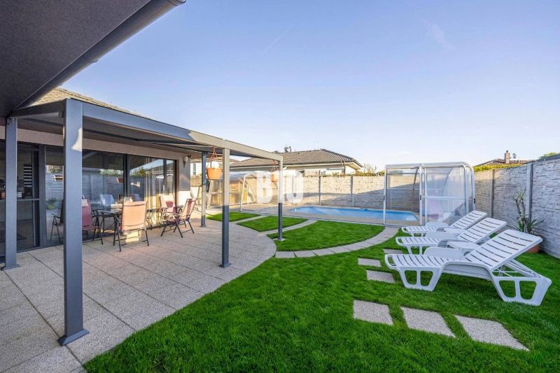 A family house in Most pri Bratislave with a terrace, a swimming pool, and sun loungers on the lawn.