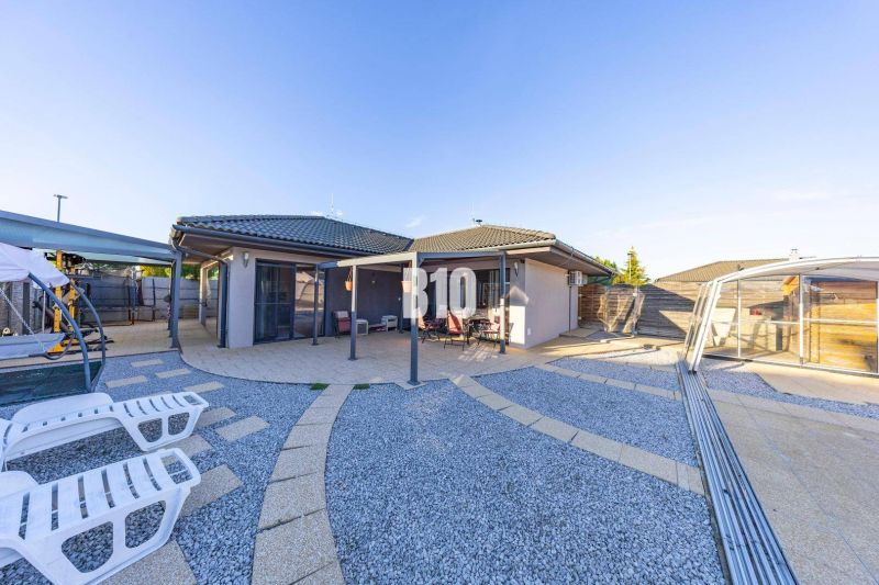 A family house in Most pri Bratislave with a terrace and a pool surrounded by pebbles.