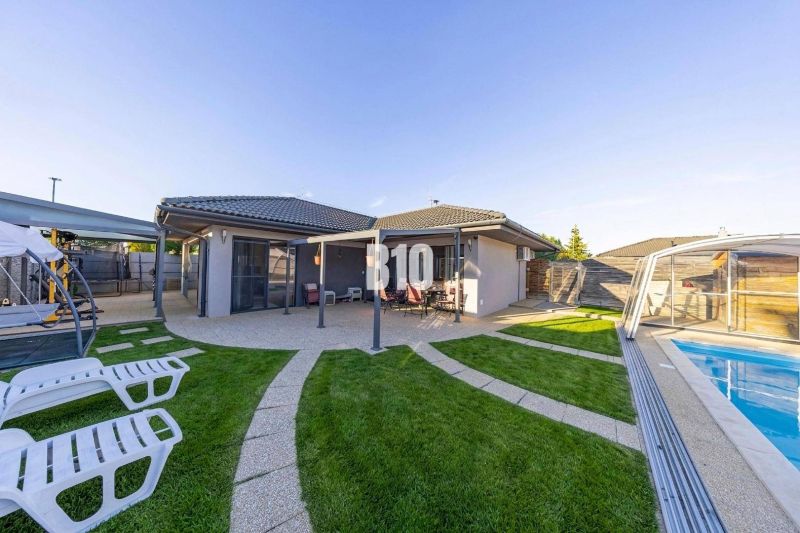 A family house in Most pri Bratislave with a terrace, a swimming pool, and sun loungers in the garden.