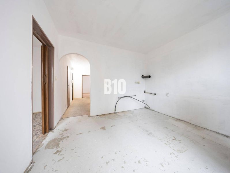 Unfurnished room in a 4-room apartment with white walls and a concrete floor.