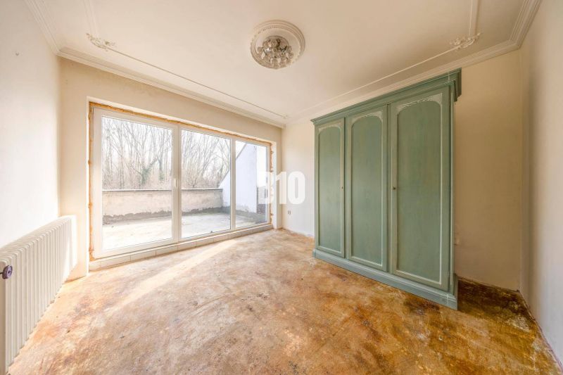 The interior of a room in a family house with a large green wardrobe and glass doors.