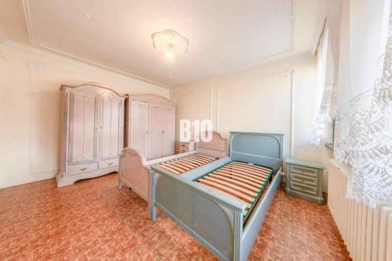 A bedroom in a family house with a wood-decor floor, beds, and wardrobes.