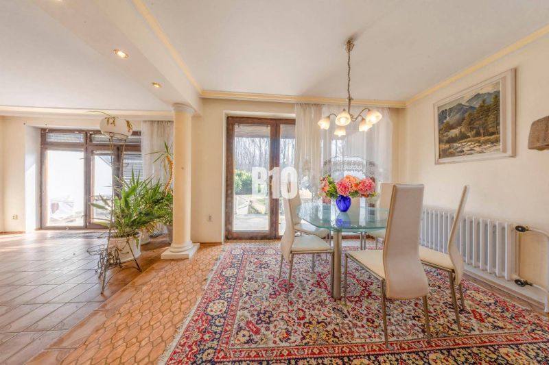 A dining table in a family house with carpets and flowers on the table.