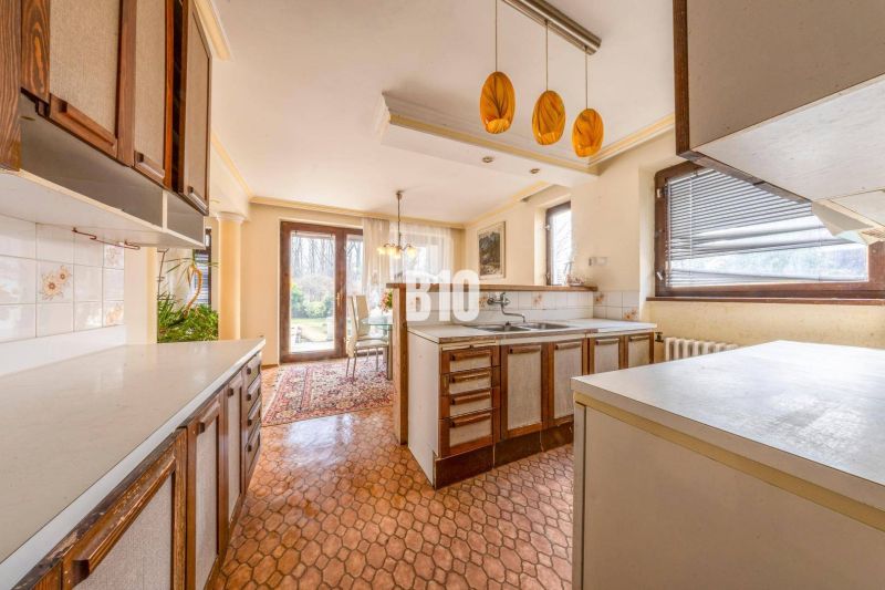 A kitchen in a family house with a dining area, windows, and access to the garden.