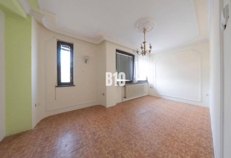 Living room in a family house with a chandelier and wooden decor flooring.