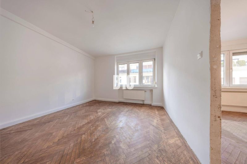 Bright room with wood-decor flooring in a 3-room apartment for rent.