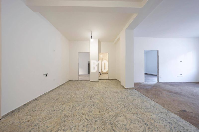 A spacious room in a 3-room apartment with ceramic and wooden flooring awaits renovation.