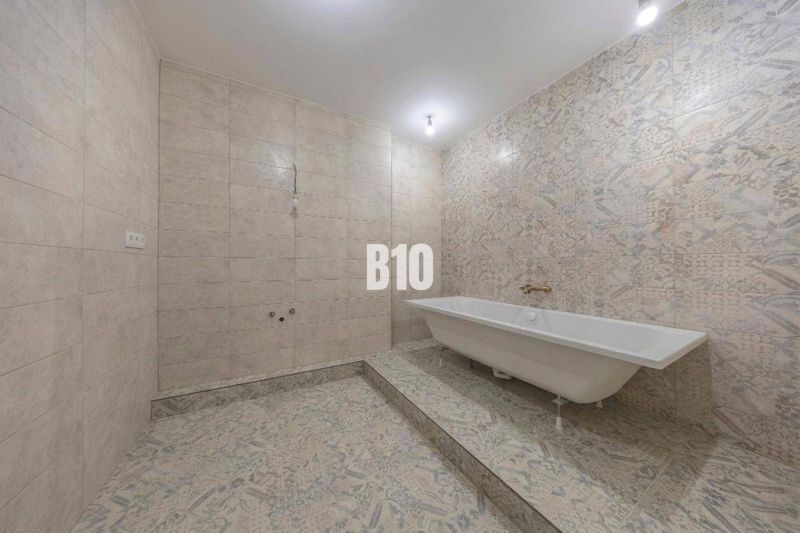 A bathroom in a 3-room apartment with a bathtub and decorative tiles.