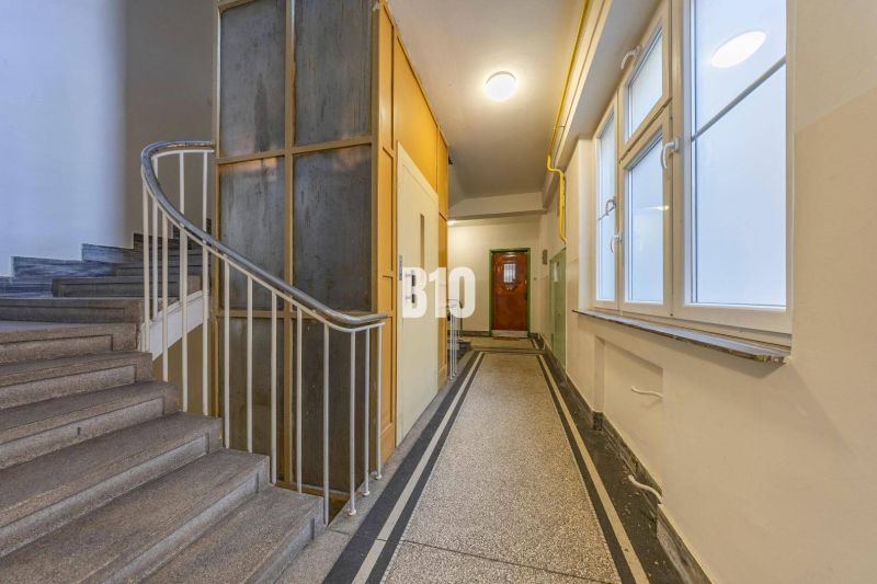 Staircase with an elevator and windows in the building entrance.