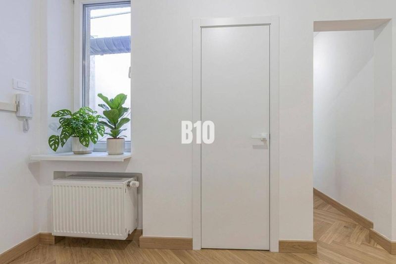 Interior of a 3-room apartment with plants on the windowsill and a floor with a wooden decor.