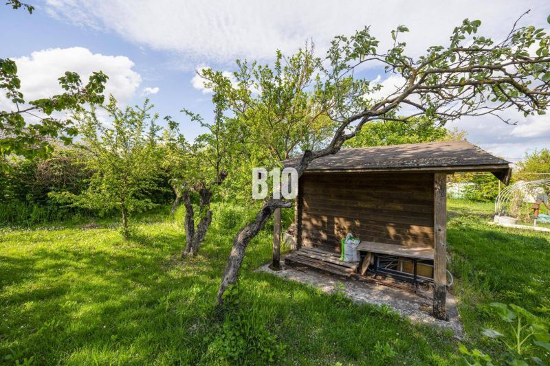 A garden with a wooden shelter on a plot in Dunajská Lužná, suitable for living.