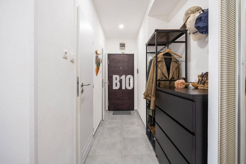 A hallway with dark furniture in a 2-room apartment with a tiled floor.