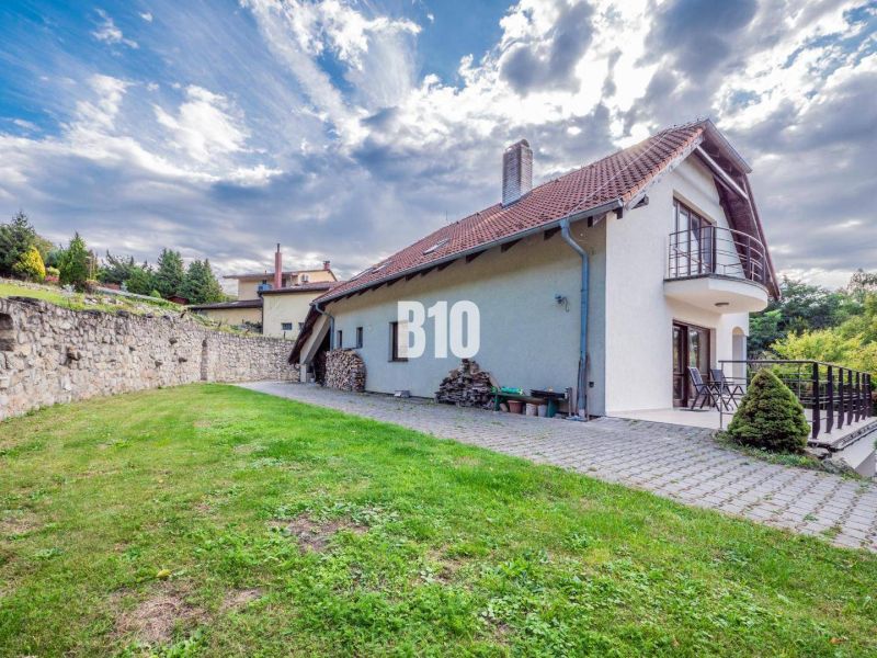 A family house in Marianka, with a terrace and lawn, surrounded by a stone wall.