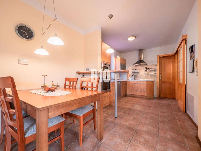 A kitchen in a family house with wooden furniture and ceramic tiles.