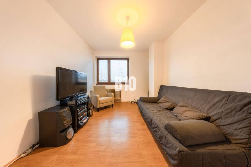 Living room in a family house with a sofa, TV, and floor with wood decor.