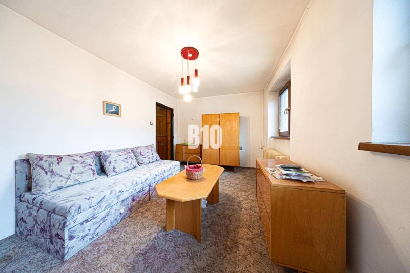 Living room in a family house with a sofa and wooden furniture.