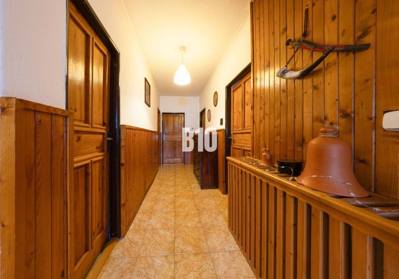 A hallway in a family house with wooden paneling and clay pots for decoration.