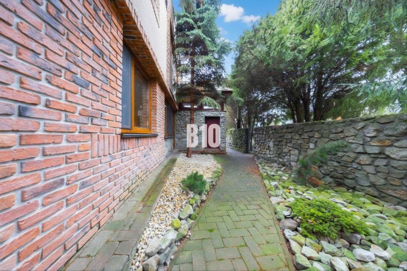 A family house in Štvrtok na Ostrove with a brick facade and a stone path in the garden.