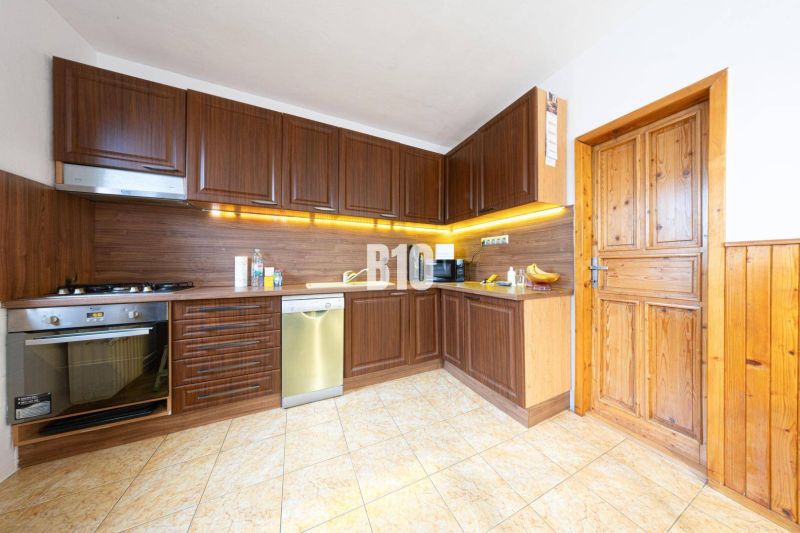 A kitchen with wooden cabinets, a floor with a wooden decor in a family house.