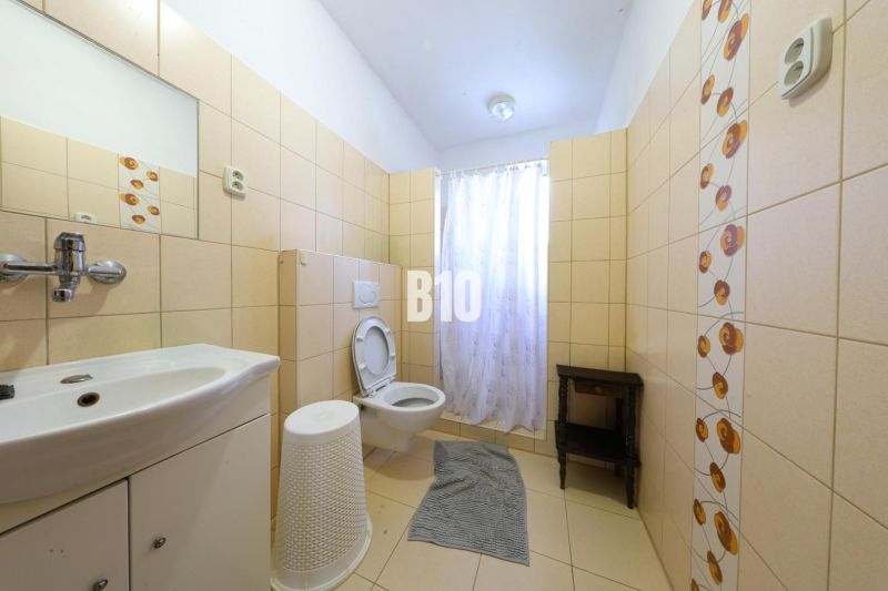 Bathroom in a family house with tiles and a toilet.