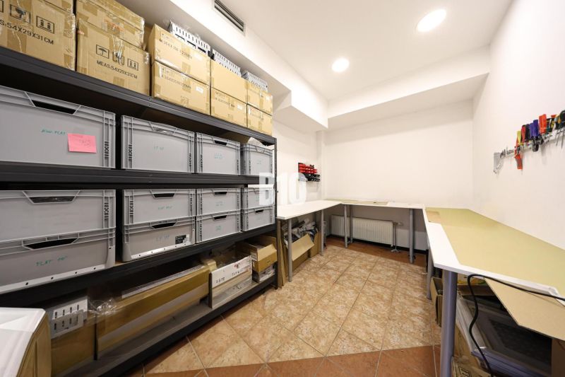 Warehouse spaces with shelving systems and folding tables.