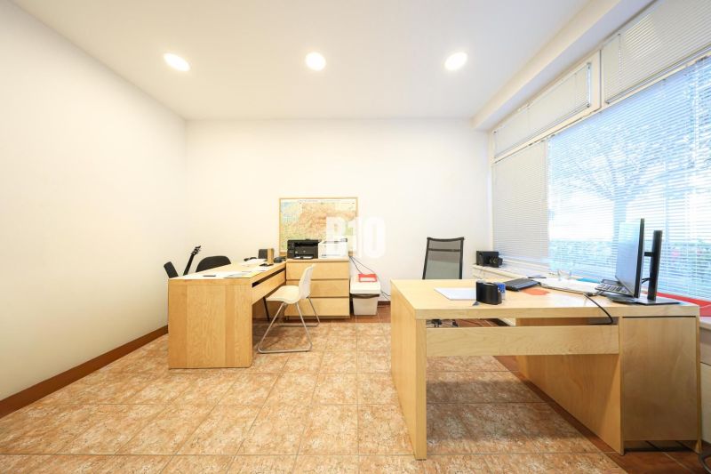 Office with wooden furniture and a large window, commercial premises.