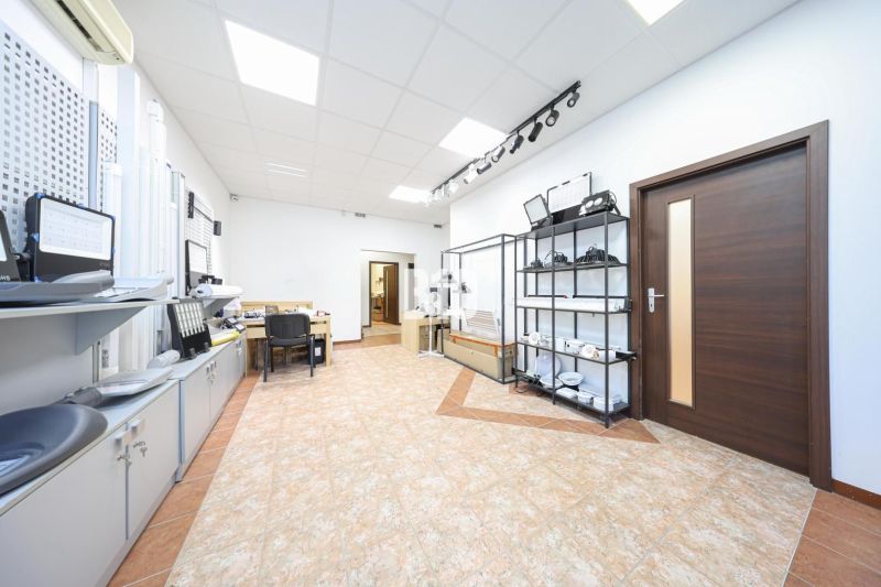 Commercial premises with office furniture, shelves, and flooring with a wood decor.