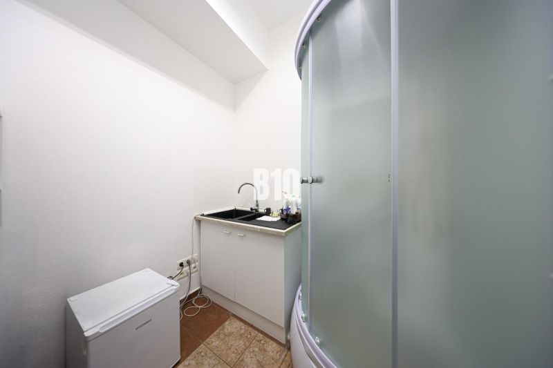 Shower corner and kitchen sink in commercial premises with a white interior.