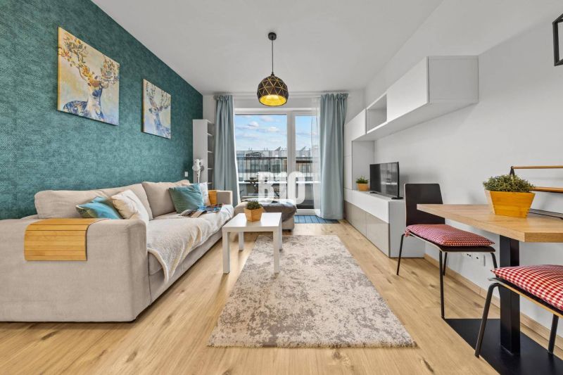 Living room with a sofa, blue wall, table, and wood-patterned floor.