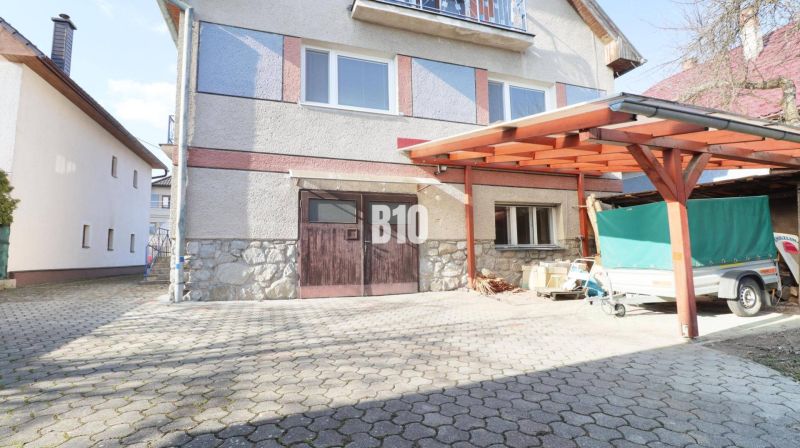 A family house in Turany with a wooden shelter and a driveway.