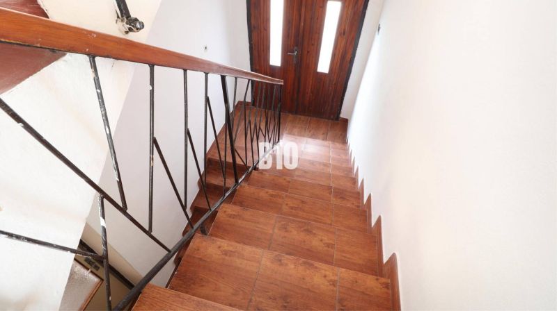 Stairs with a wooden decor floor and metal railing in a family house.